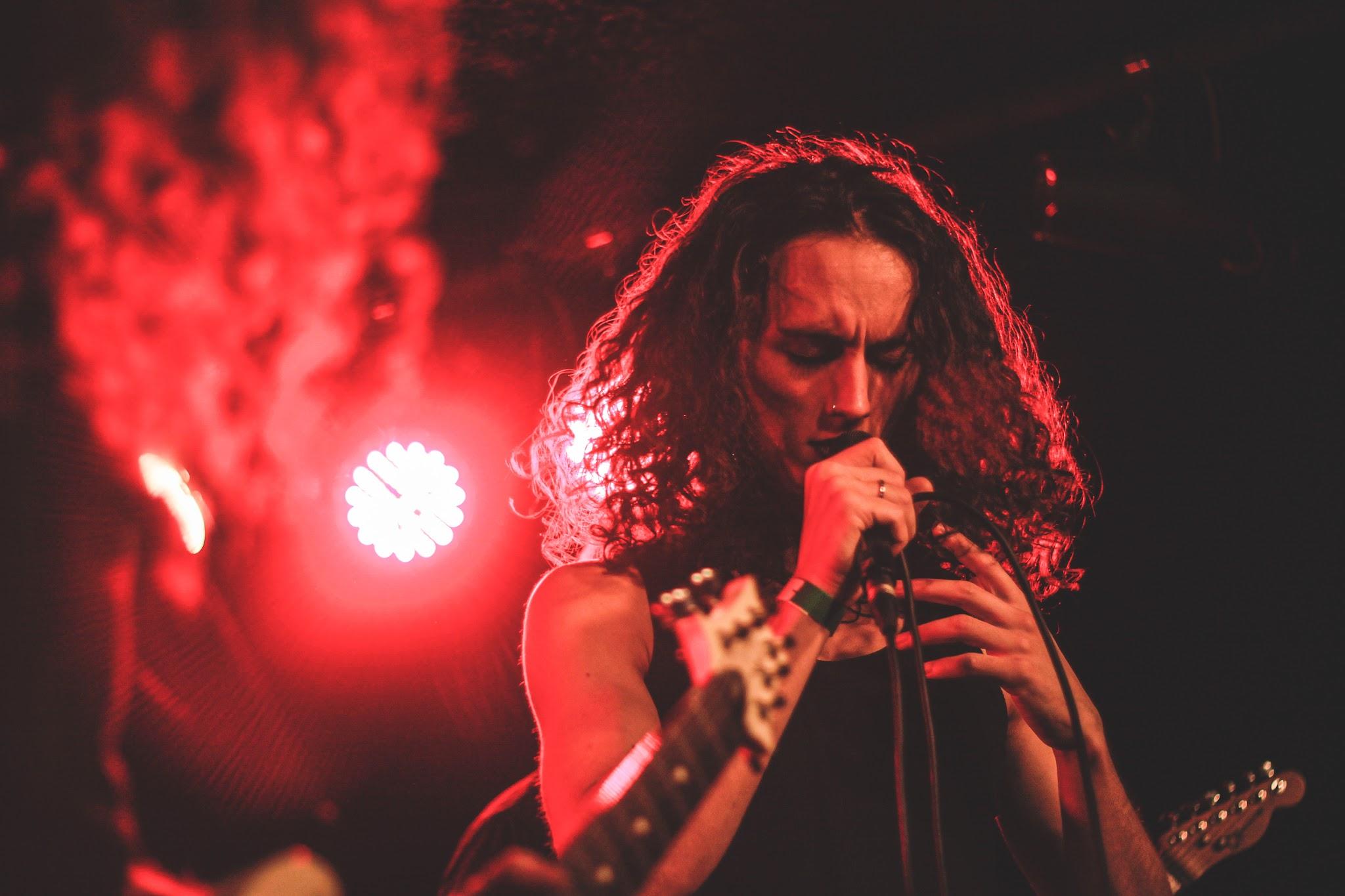 About Us Bild 11, Mann an Mikrofon